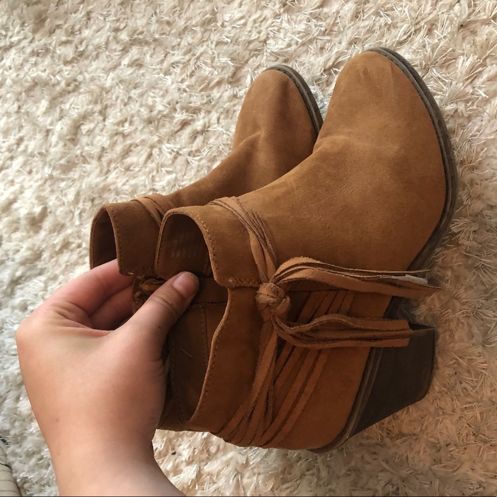 Heeled brown tasseled boots.